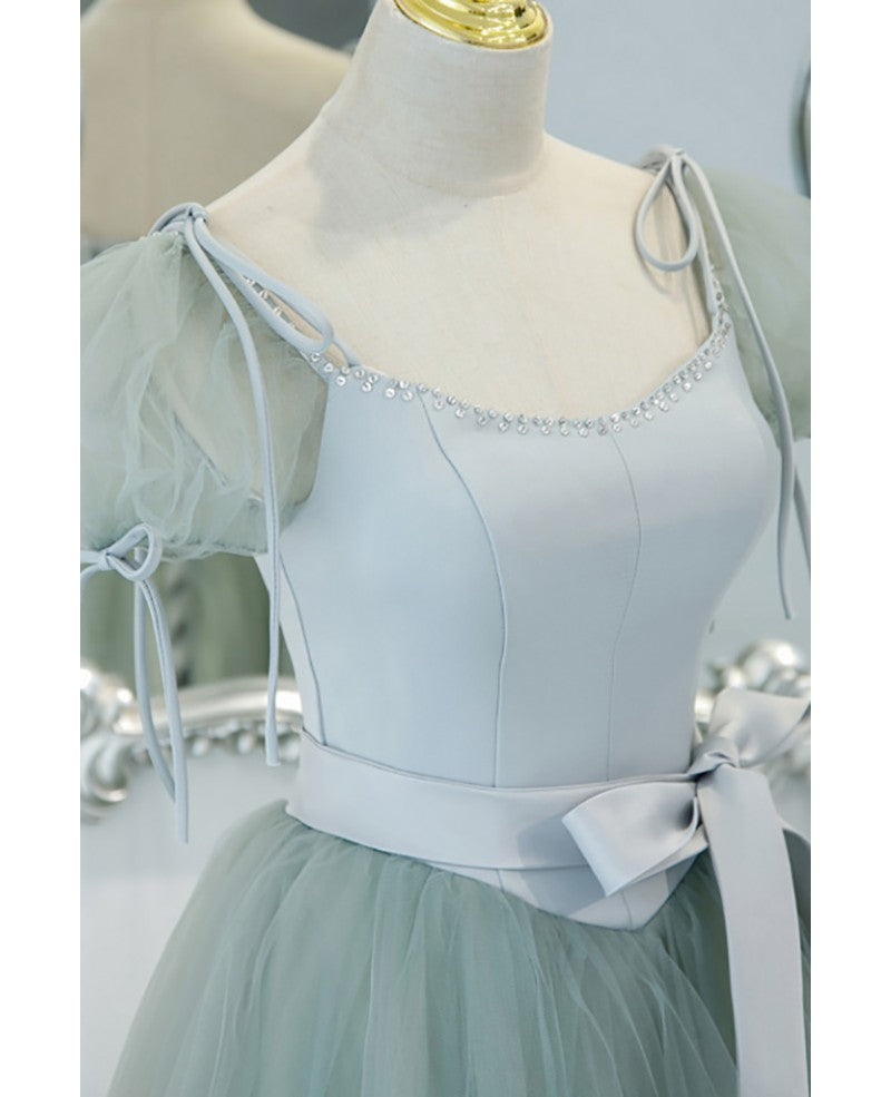 Unico ed elegante abito da ballo verde menta con scollo quadrato, maniche corte e soffice, cintura con fiocco verde menta e spalline scoperte sulla schiena e abito da ballo lungo fino al pavimento.